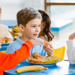 preschool aged children eating lunch at a table